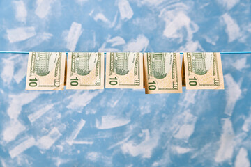 10 dollar bills hang on a clothesline