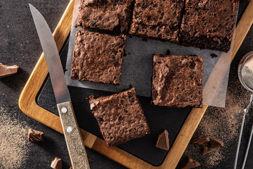 Homemade pieces of brownies on black background. Top view