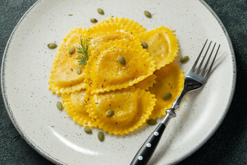 Homemade Pumpkin Ravioli with butter on a dark concrete background. Top view