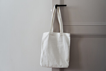 Eco friendly concept with white canvas tote bag hanging on door knob with two toned colored, Eco...