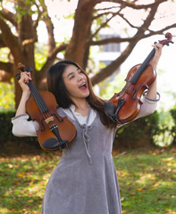 Young beautiful lady holding violin in hand,show how to play acoustic instrument,