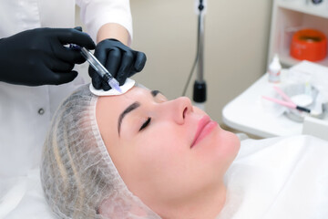 Cosmetic injections for skin rejuvenation. Cosmetologist injects a syringe into the skin
