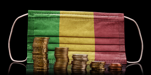 Medical mask with the flag of Mali behind some shrinking stacks of various coins.(series)