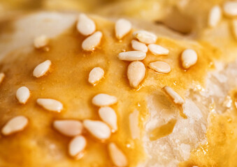 Yeast dough puff with sesame seeds, close-up. Delicious pastries