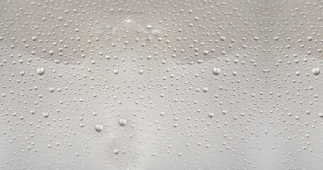 Small water droplets on a gray background closeup view