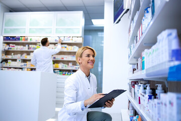 Naklejka na ściany i meble Pharmacists working in pharmacy shop or drugstore. Healthcare and medicine.
