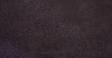 Rustic black background with fresh water droplets closeup view