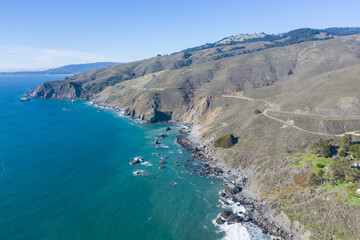 The Pacific Ocean washes against the rugged shoreline of northern California on a beautiful winter day. The scenic Pacific Coast Highway runs along much of the edge of California.