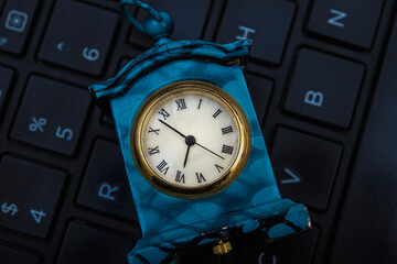 Vintage clock miniature on keyboard closeup view