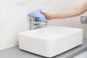 Woman with rag cleaning bathroom at home