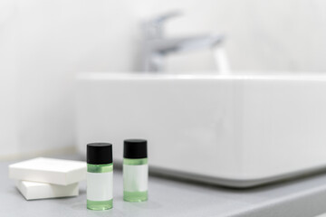 Mini bottles with cosmetic products in bathroom