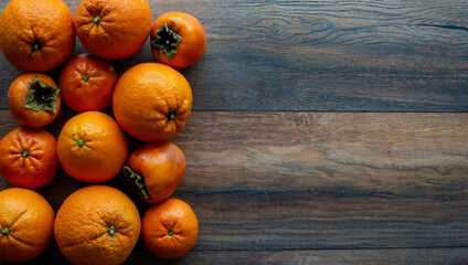 Food background. Orange, tangerine, persimmon on the wooden table