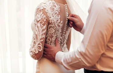 
bride and groom dress up in the bedroom