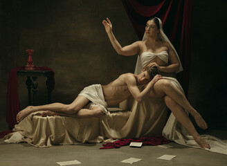 Feelings. Modern remake of classical artwork - young medieval couple on dark background, golden colored. Concept of art, creativity, comparison of eras, history, modernity and renaissance.