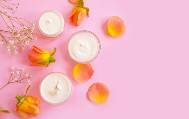 Obraz na płótnie Canvas cream cosmetic rose flower on colored background