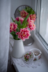 Obraz na płótnie Canvas Still-life. A bouquet of red tulips on the windowsill.