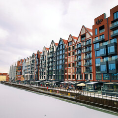 Beautiful colorful townhouses on the banks of the frozen Motlawa River in Gdansk, Poland