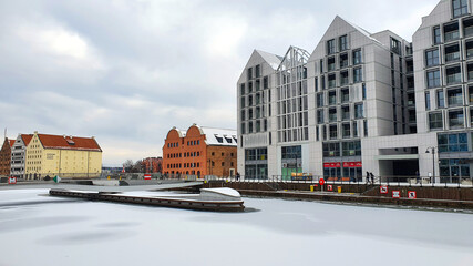 Naklejka premium Beautiful colorful townhouses on the banks of the frozen Motlawa River in Gdansk, Poland