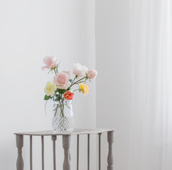 beautiful roses in glass jug on white background