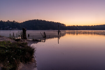 Early sun over the lake. Purple sky and purple lake. Purple sunrise over the lake.