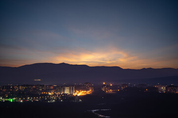 Fototapeta na wymiar City in the background of mountains and river at sunrise