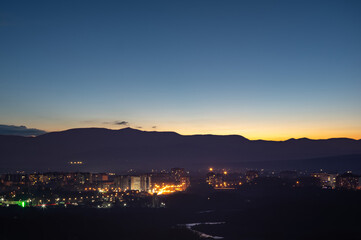 Obraz premium City in the background of mountains and river at sunrise