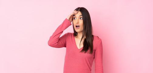 Young caucasian woman over isolated background doing surprise gesture while looking to the side