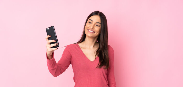 Young caucasian woman over isolated background making a selfie