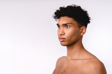 Side view portrait of a handsome young mixed-race shirtless man isolated over white background