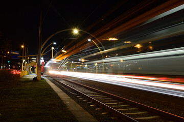 Fototapeta na wymiar Tram at night, blurred traffic, tram stop