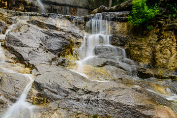 Fototapeta na wymiar Beautiful waterfall on small river in a park