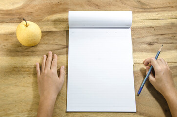 hand with pencil and paper  on wooden background