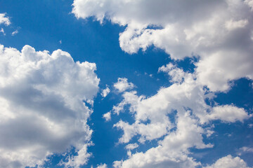 Naklejka na ściany i meble White gray clouds floating in the high blue summer sky.