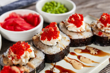 japanese sushi rolls in a rectangular plate on a light wooden table