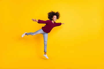 Full body profile portrait of dark skin girl hands show plane figure wear pullover isolated on yellow color background