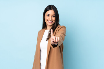 Young caucasian woman isolated on blue background showing and lifting a finger