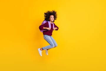 Fototapeta na wymiar Full length profile portrait of dark skin girl jump carry bag wear pullover isolated on yellow color background