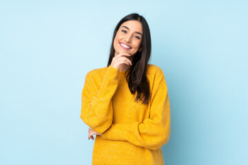 Young caucasian woman isolated on blue background happy and smiling