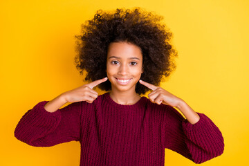Photo of beautiful wavy hairdo dark skin schoolgirl indicate fingers toothy smile isolated on yellow color background