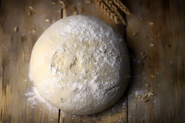 Selective focus. Yeast dough for baking bread and ears of wheat. Homemade bread making.