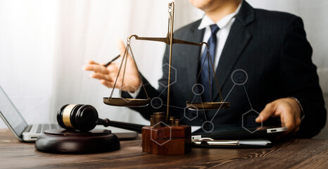 Justice and law concept.Male judge in a courtroom with the gavel, working with, computer and docking keyboard, eyeglasses, on table in morning light