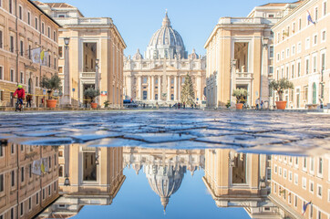 Fototapeta na wymiar Rome, Italy - in Winter time, frequent rain showers create pools in which the wonderful Old Town of Rome reflects like in a mirror. Here in particular the St. Peter's Basilica 