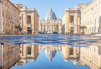 Fototapeta premium Rome, Italy - in Winter time, frequent rain showers create pools in which the wonderful Old Town of Rome reflects like in a mirror. Here in particular the St. Peter's Basilica 