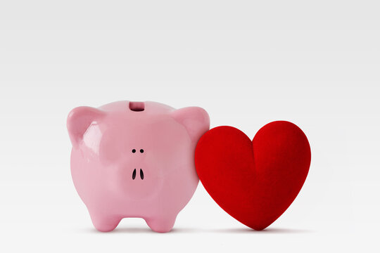 Piggy bank with heart on white background - Concept of love and money