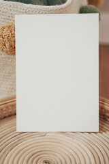 White invitation cards in a wooden wicker basket in boho style
