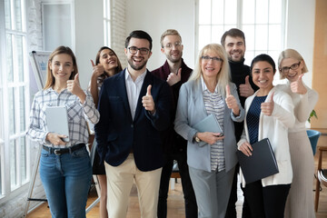 Portrait of successful mature businesswoman and team showing thumbs up Happy interns satisfied with...