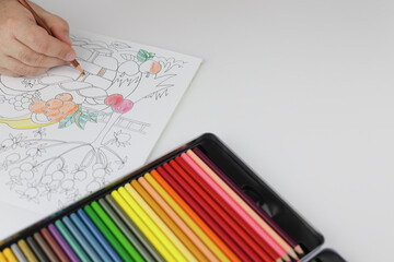 Drawing mandala anti stress with multicoloured pencils during lockdown.