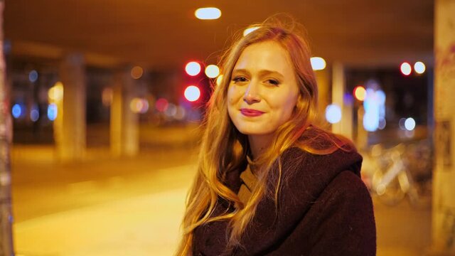 [4k] Young Blonde Woman Putting Off Ffp2 Face Mask In Yellow Streetlight At Night Under A Bridge