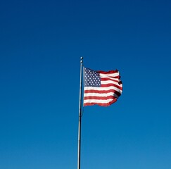 The america flag with the bright blue sky background.