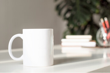 Fototapeta na wymiar White cup of tea on white table in office